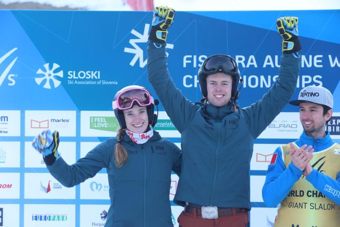A female and male skiers are celebrating on the podium